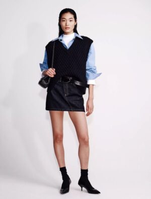 Woman wearing a calvin klein Poplin Woven Cropped Button-Down Shirt and standing to prominent the CK shirts.