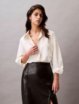 Woman wearing a calvin klein Viscose Blend Relaxed Button-Down Shirt and standing to prominent the CK shirts.
