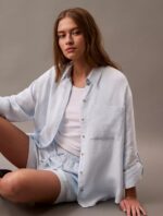 Woman wearing a calvin klein Double Gauze Roll Tab Button Down Shirt and standing to prominent the CK shirts.